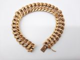 un bracelet en chaîne dorée avec un fermoir, sur fond blanc