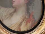 painting of a woman in a gold frame with a red bow
