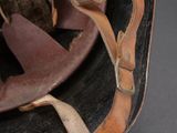 an old helmet with a leather strap is on a black surface
