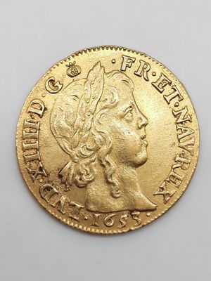 gros plan d'une pièce d'or sur une surface blanche