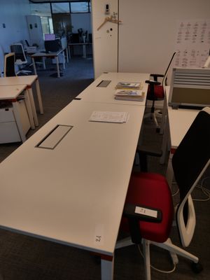 une longue table avec une chaise rouge au milieu de la pièce