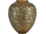 a gold vase that is sitting on a white surface