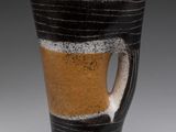 une tasse noire et blanche ornée d'une rayure marron