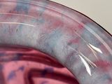 a close up of a pink vase with a blue and white design