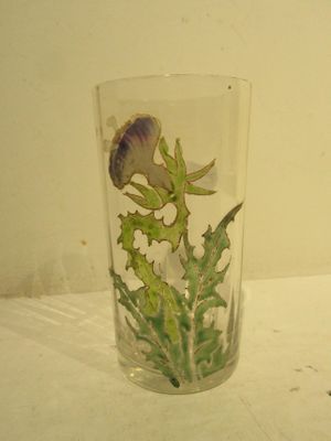 a glass with a flower inside of it on a table