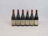 six bouteilles de vin alignées sur une surface blanche