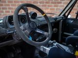 a steering wheel and dashboard of a car with a brick wall in the background