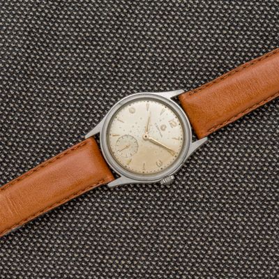une image représentant une montre avec un bracelet en cuir marron sur un fond noir