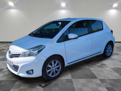a white toyota yaris parked in a room with a checkered floor