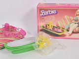 une poupée Barbie assise sur une chaise à côté d'une boîte à goûter