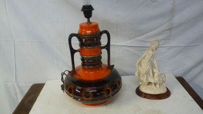 deux vases posés sur une table, avec une statue en arrière-plan