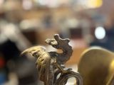 a gold vase with a dragon on it and a spoon in it