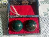 deux boules vertes dans une boîte rouge posée sur une table