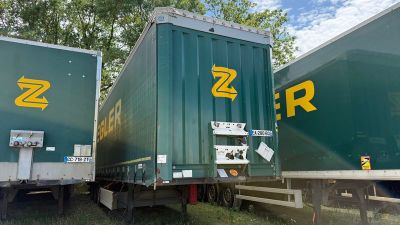 deux semi-remorques vertes garées l'une à côté de l'autre dans l'herbe