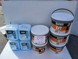 several buckets of paint sitting on a table next to each other