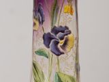 un vase en verre orné de fleurs peintes, posé sur une table