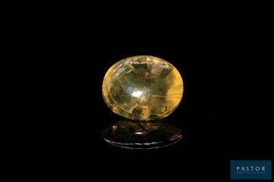 a close up of a yellow crystal ball on a black surface