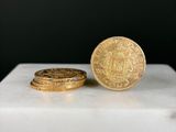 deux pièces d'or posées l'une sur l'autre sur une surface en marbre