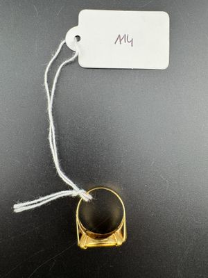 a close up of a gold ring with a black stone on it