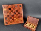 two wooden chess pieces in a wooden box on a black background