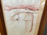 painting of a nude woman in a wood frame on the floor