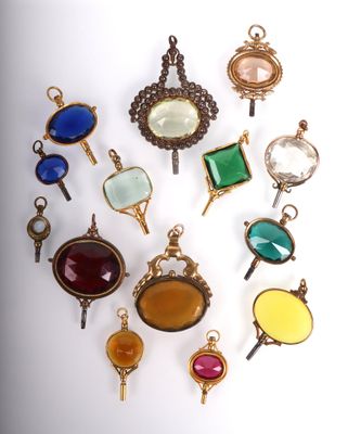 an image of a group of different colored glass pendants on a white surface