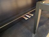 a black piano sitting on a carpeted floor next to a table