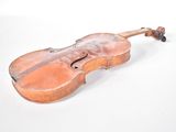 an old violin sitting on a white surface with a white background