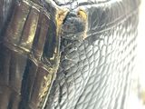 a close up of a black purse with a gold buckle