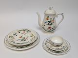 a tea pot, plate, and cup on a white table