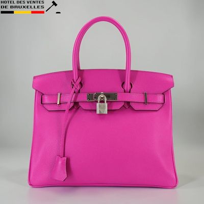 un sac à main en cuir rose muni d'un cadenas sur la poignée