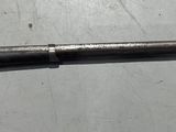 un fusil posé sur une table, avec une arme fixée sur le côté