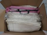 a cardboard box filled with clothes and a pink bag