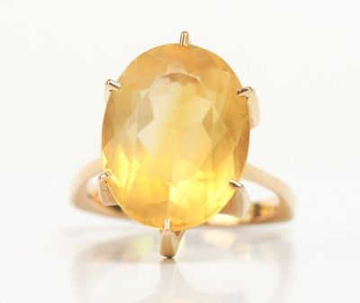 une image représentant une bague sertie d'une grosse pierre jaune