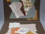 a picture of a folded card with torn pieces of paper on it