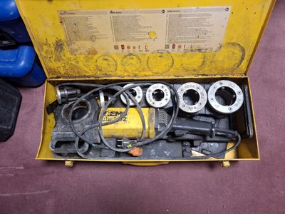 une boîte jaune posée par terre, contenant des outils