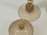 three glass candlesticks with a gold base and a glass candle holder