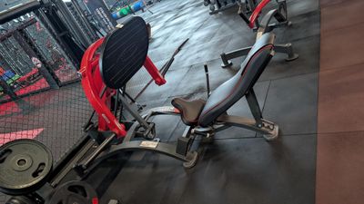a gym area with a bench, weights, and other equipment