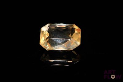 a yellow sapphire stone on a black surface