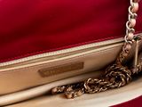 red leather purse with gold chain hanging from it ' s side
