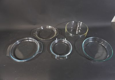 Quatre bols en verre sont posés sur une table devant un fond noir.