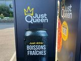 une pancarte sur laquelle est écrit « Just Queen » à côté d'une poubelle