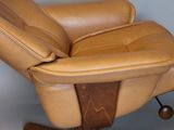 a brown leather recliner chair with a wooden base