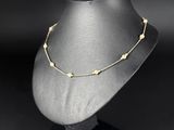 a black mannequin with a gold bead necklace on it