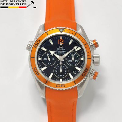 un bracelet orange sur une montre au cadran noir