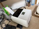 an image of a cell phone and a printer on a desk
