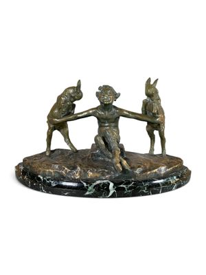 sculpture en bronze représentant un garçon et deux chiens se tenant par la main, posée sur un socle en marbre