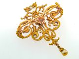 an image of a gold broochle with a gold bead