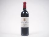 a bottle of red wine sitting on top of a white table