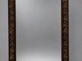 an ornately carved mirror with a wooden frame and gold decoration